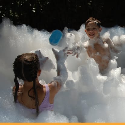 Kids playing catch inside a foam party pit