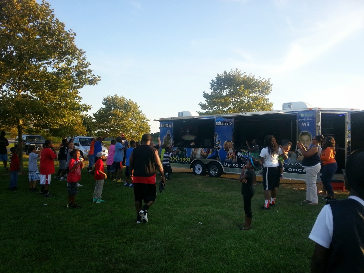 Big crowd at Party Game Truck outdoor event at golden hour